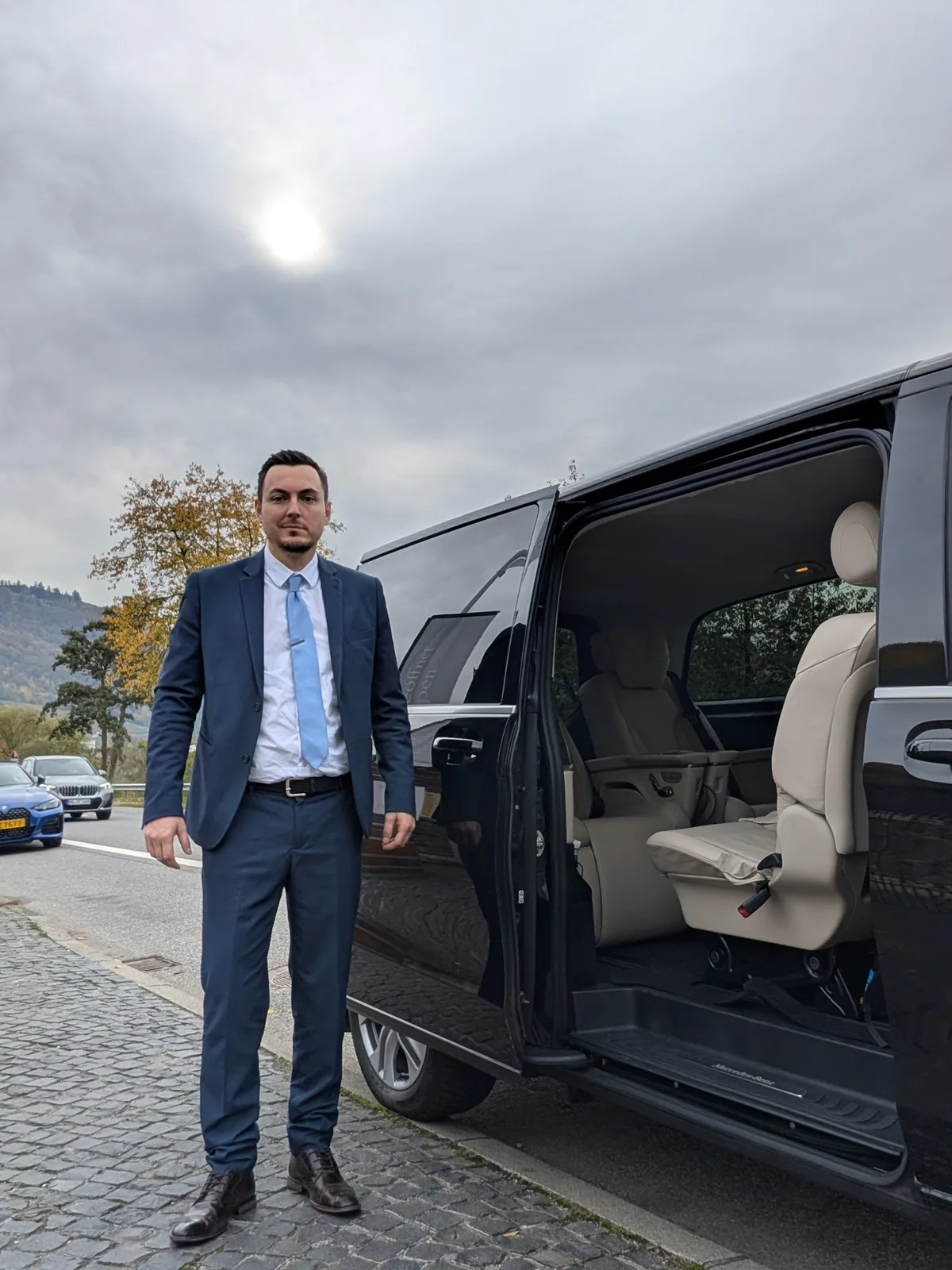 Chauffeur en costume avec minibus luxury