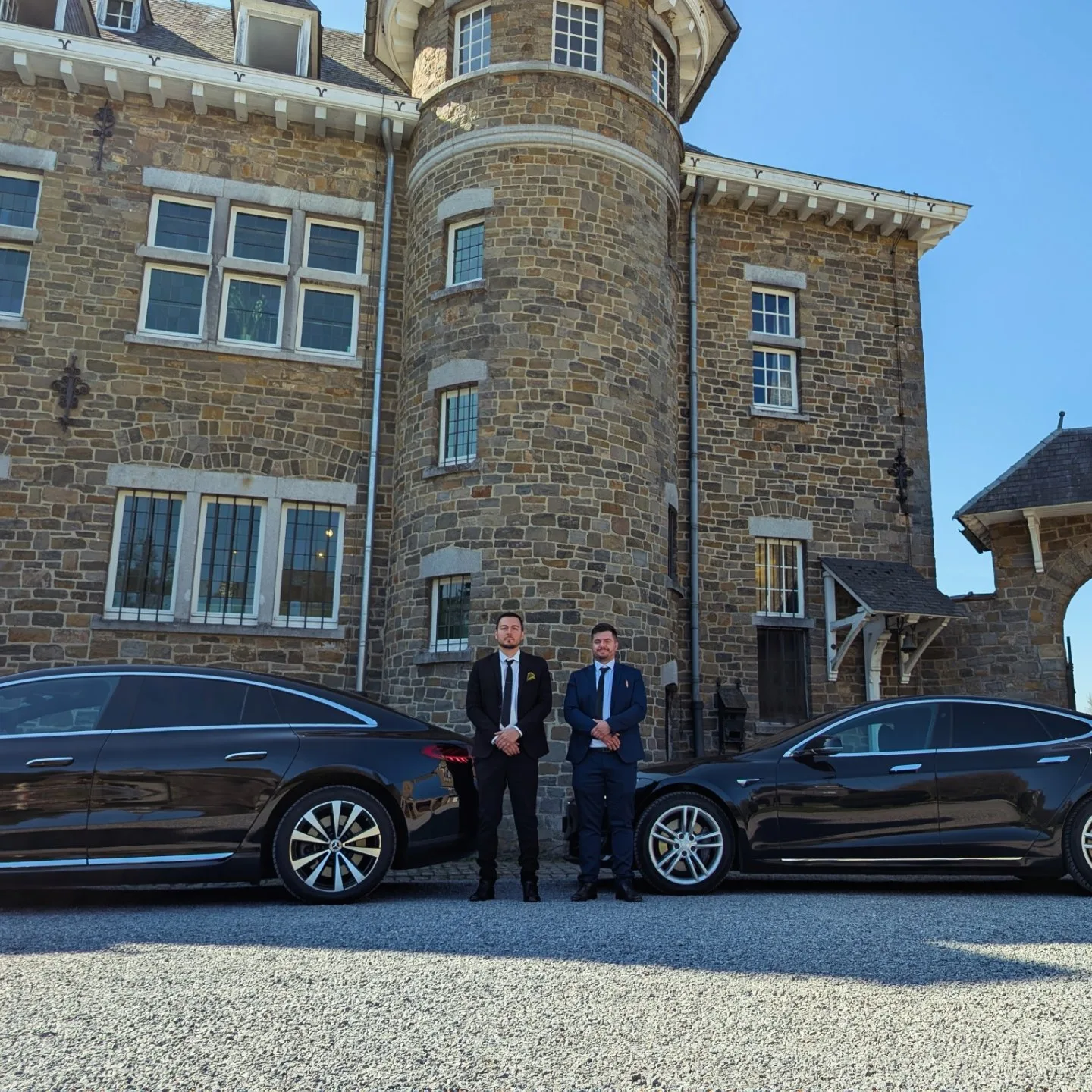 Chauffeur en costume devant un manoir de Spa